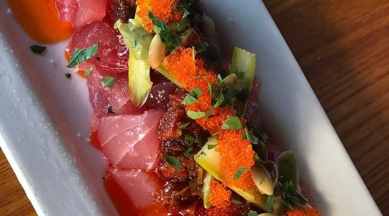 Slices of raw ahi tuna with fish roe and greens