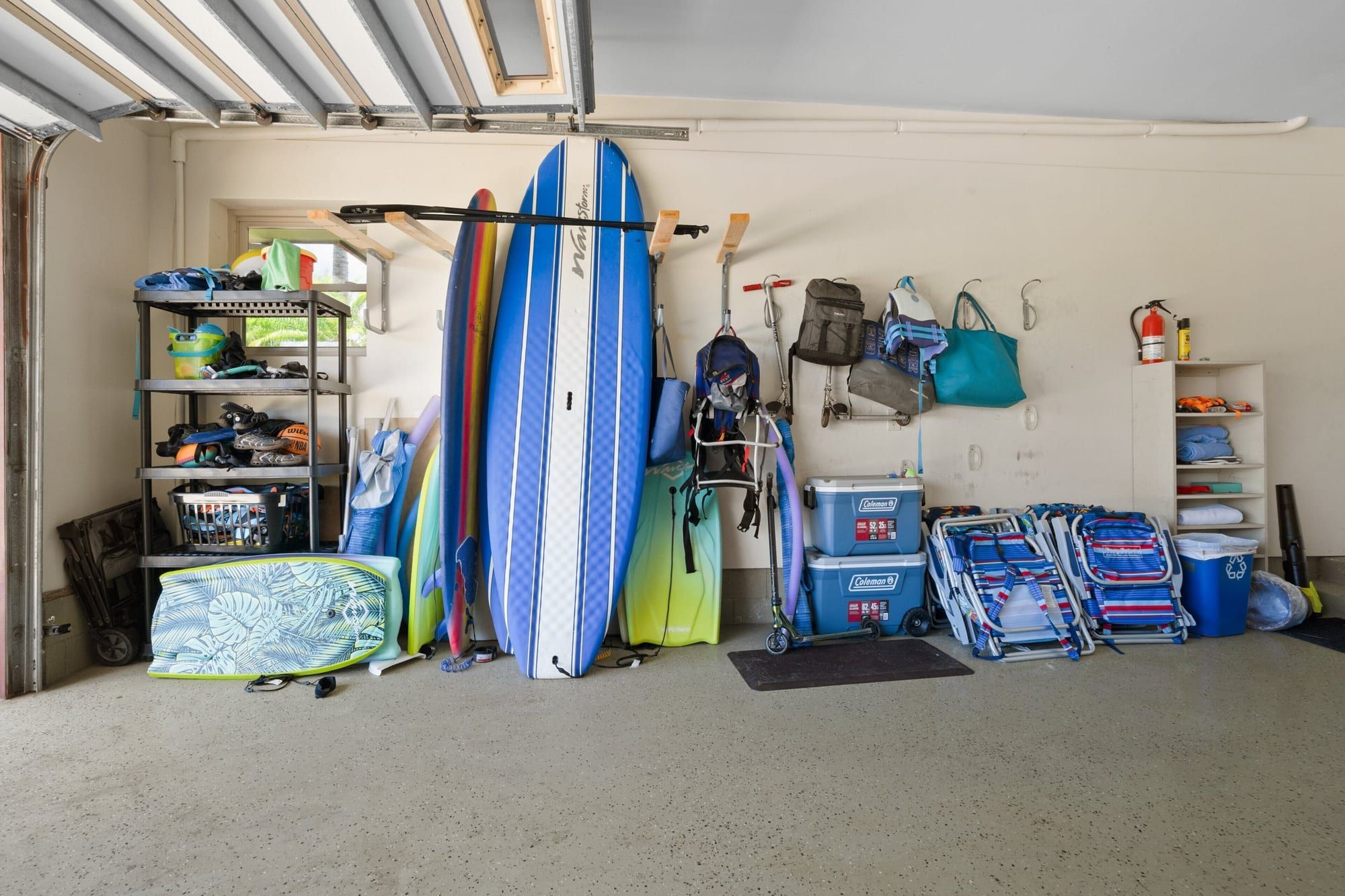 The garage stocked with surfboards, boogie boards, beach chairs, coolers and a wagon