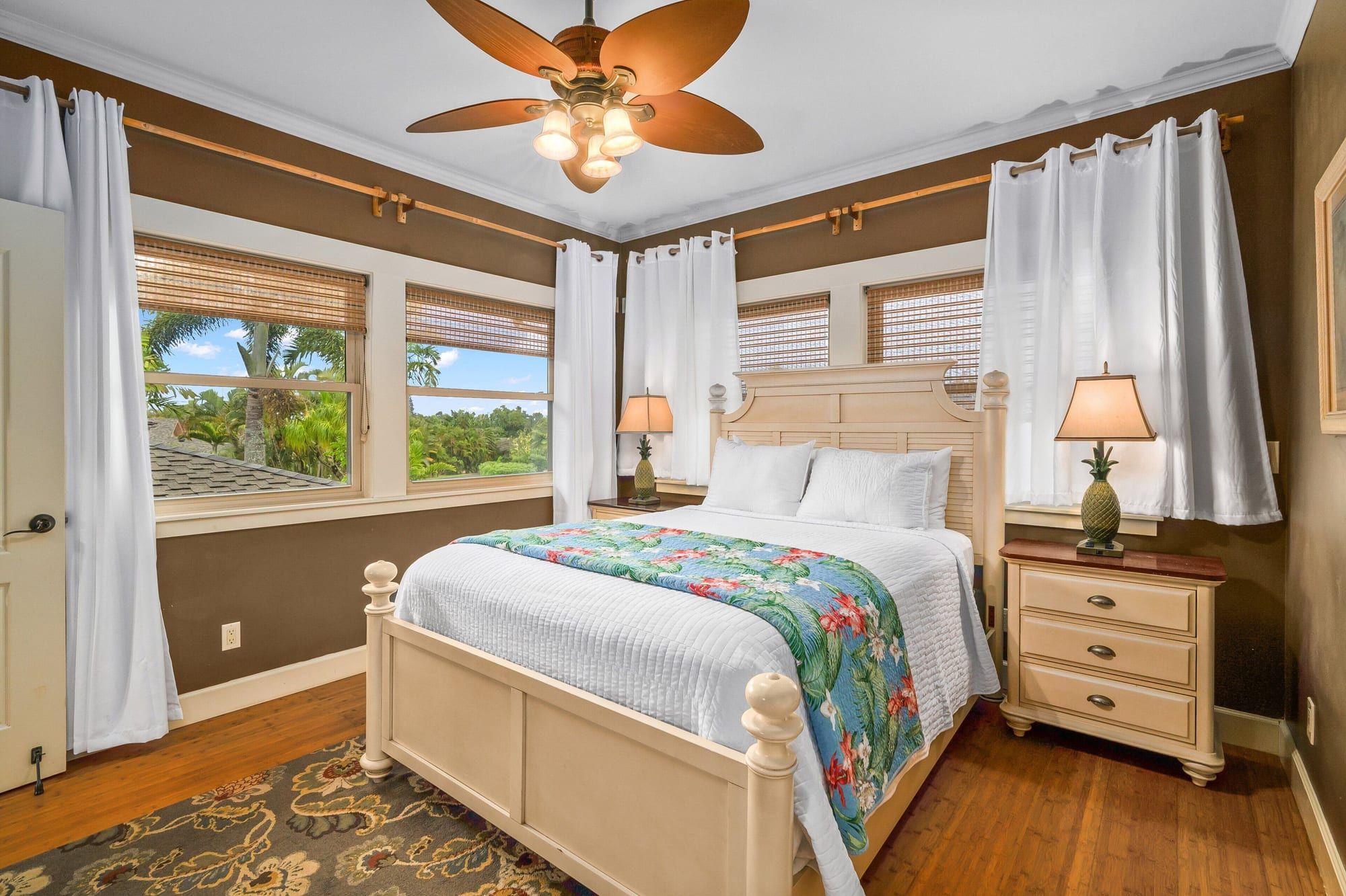 A bright bedroom with a white bed and floral runner