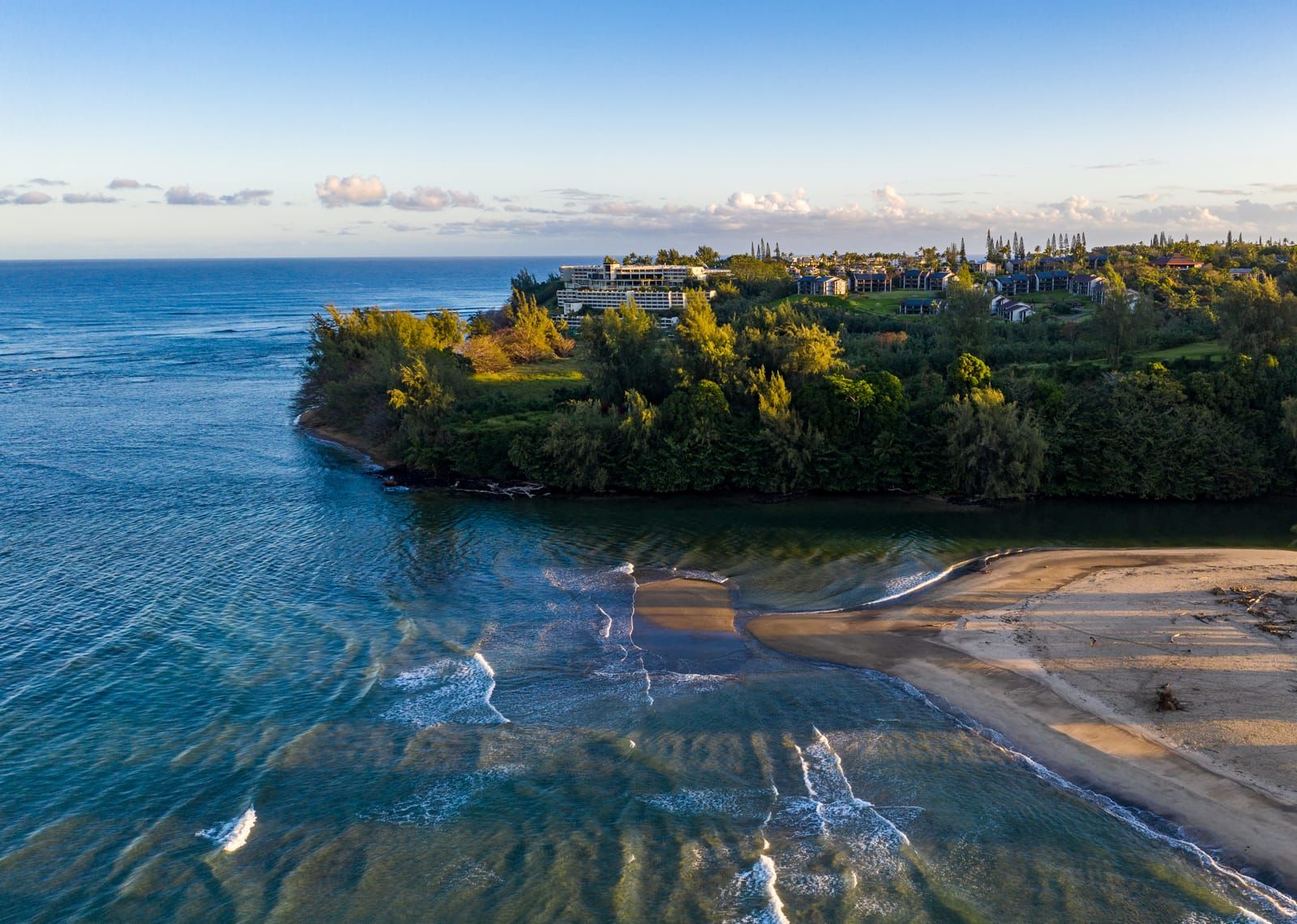 Princeville's green cliffs and a quiet beach at sunrise