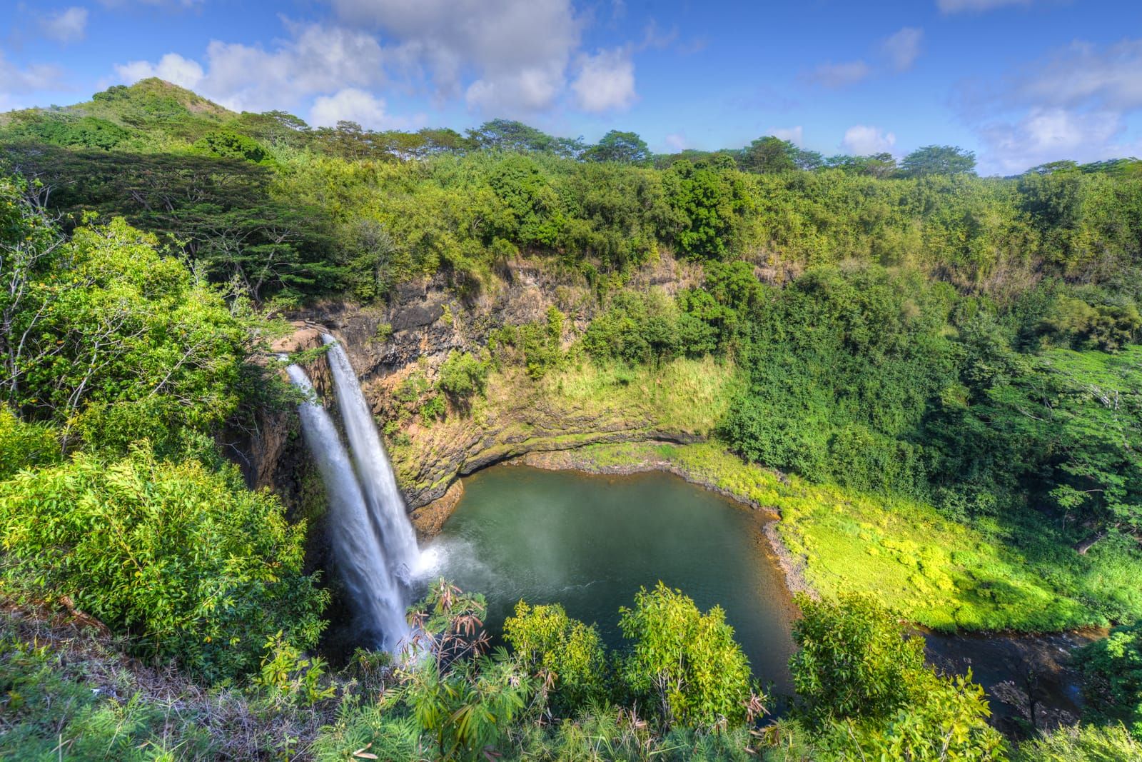 Twin ribbons of Wailua Falls dropping into a pool surrounded by jungle