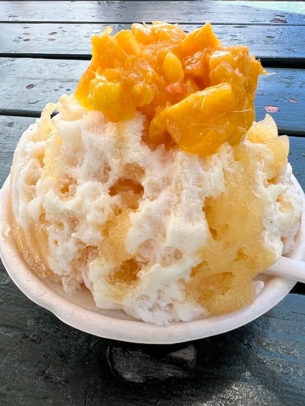 A bowl of shave ice topped with fresh mango